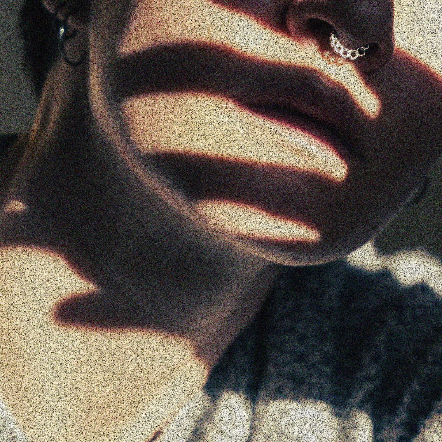 a close up photo of the bottom half of TJ's face, crossed with dark, finger-like shadows